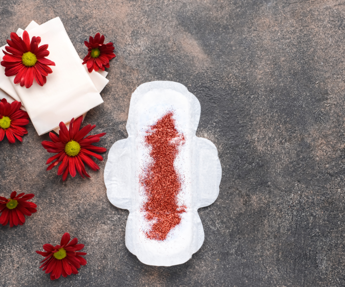 Foto de absorvente menstrual e flores vermelhas