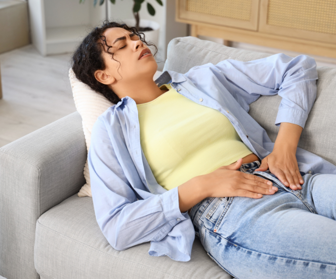 Foto de mulher deitada no sofá com dor
