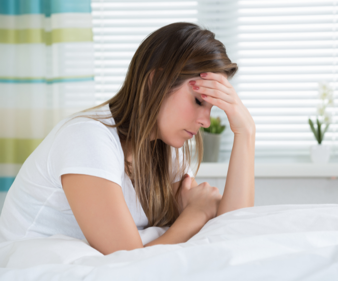 Foto de mulher com a mão na testa com a expressão de preocupada