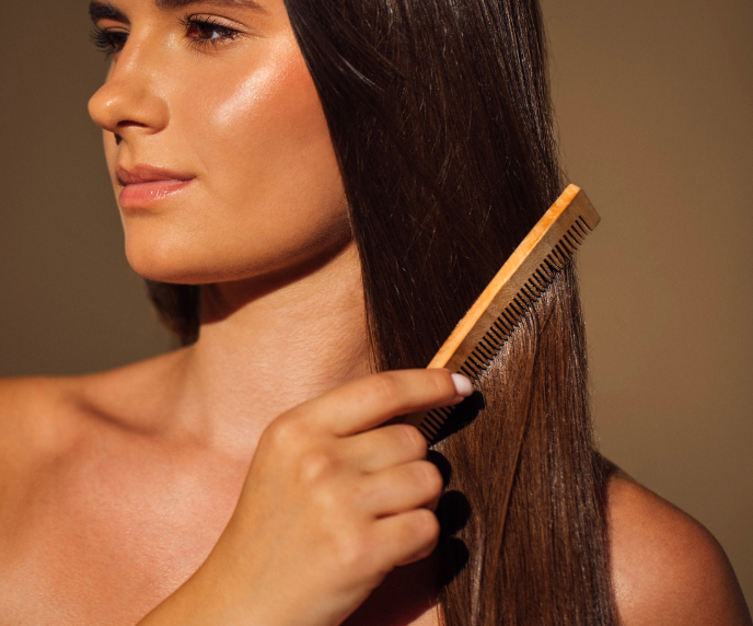 Foto de mulher penteando o cabelo com pente de madeira