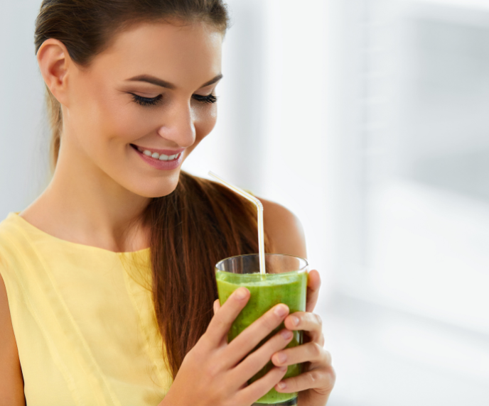 Foto de mulher com copo de suco verde