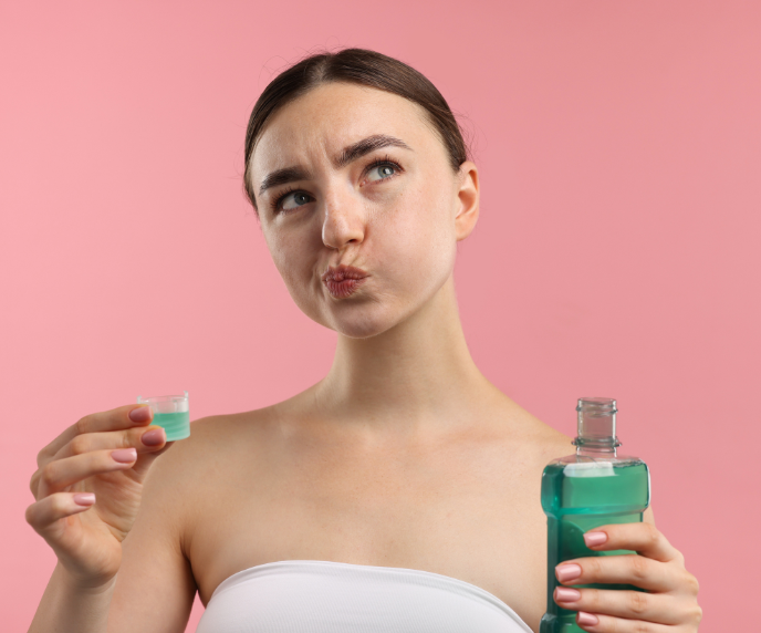 Foto de mulher enxaguando a boca com enxaguante