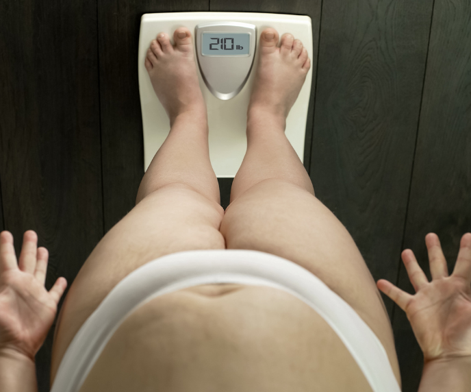 Foto de mulher se pesando na balan&ccedil;a