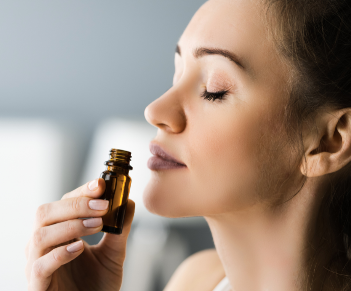 Foto de mulher cheirando óleo essencial